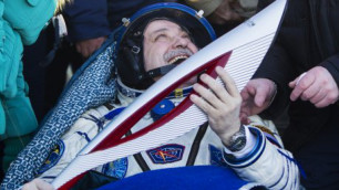 Российский космонавт Федор Юрчихин держит в руках олимпийский факел после приземления. Фото ©REUTERS